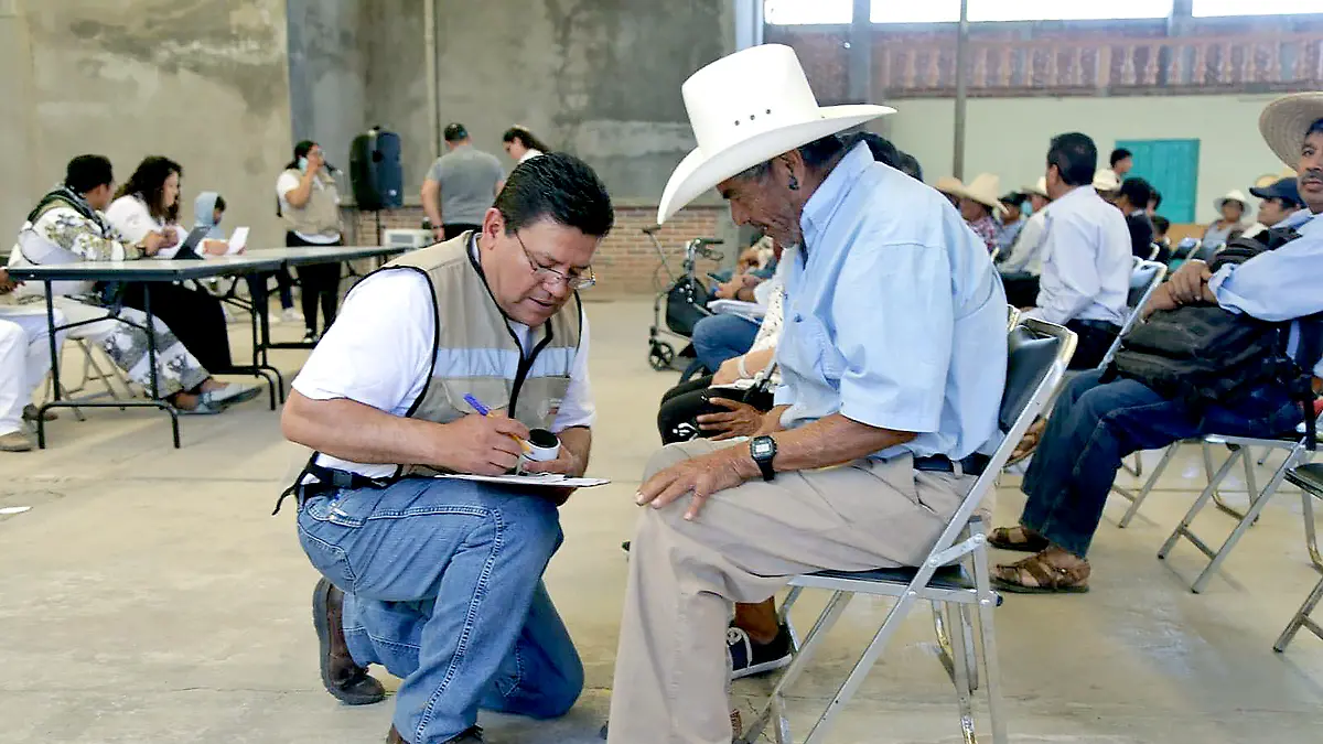 Servidor de la nación atendiendo a una persona de la tercera edad