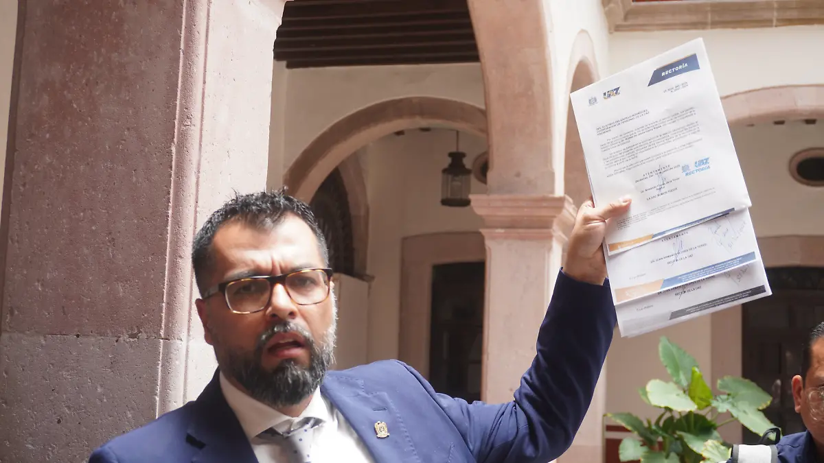 Rector de la UAZ muestra documentos.