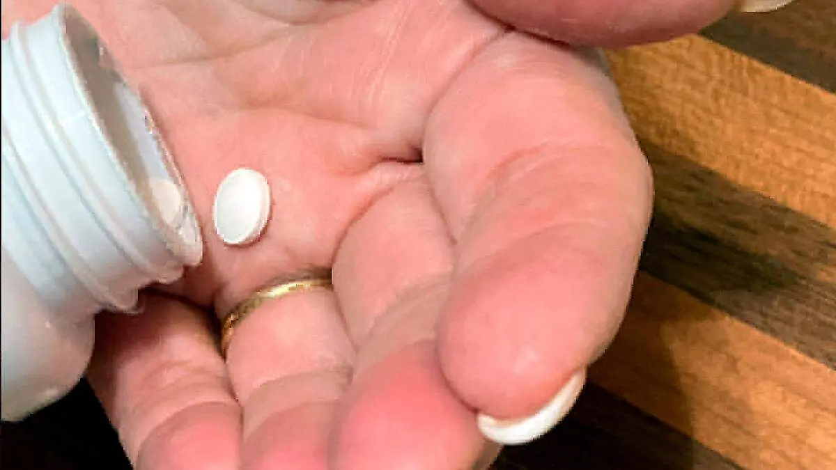 Persona sosteniendo una pastilla