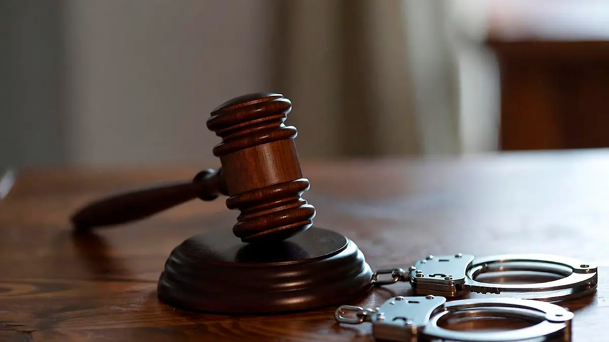Imagen ilustrativa de un mazo de juez y esposas policiales