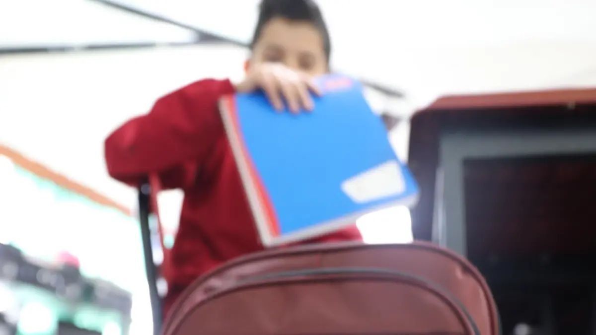 Niño guardando sus útiles escolares