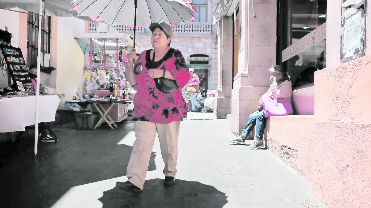 Mujer se cubre con sombrilla del intenso calor en Zacatecas