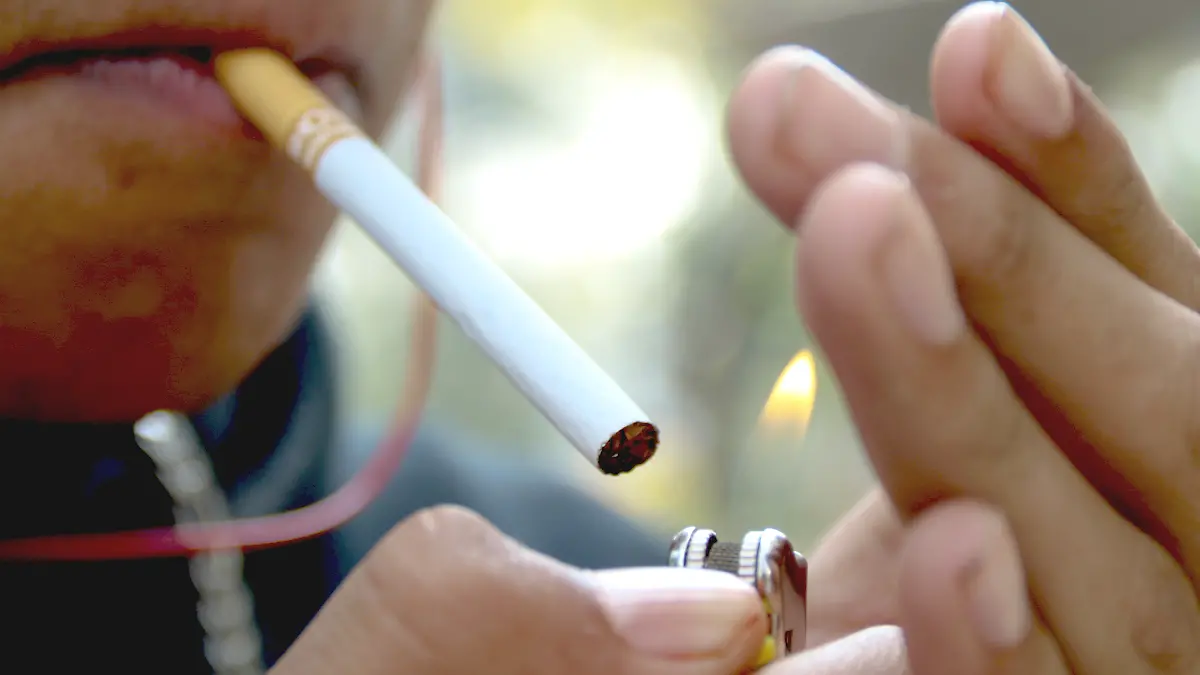 Persona encendiendo un cigarrillo