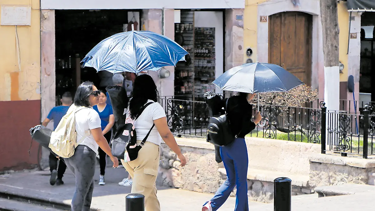 Personas se cubren de los intensos rayos del sol en el centro de la ciudad de Zacatecas
