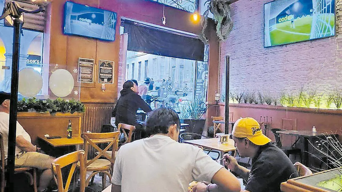Comensales en restaurante viendo partido de futobl
