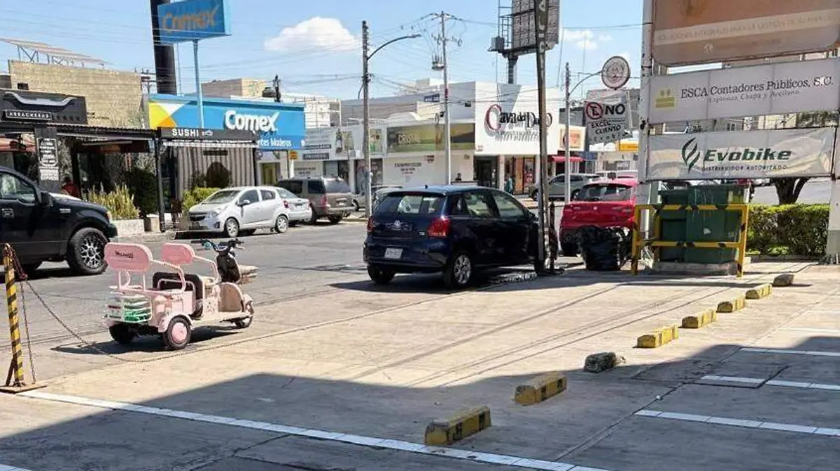 Automóviles estacionados sobre la banqueta