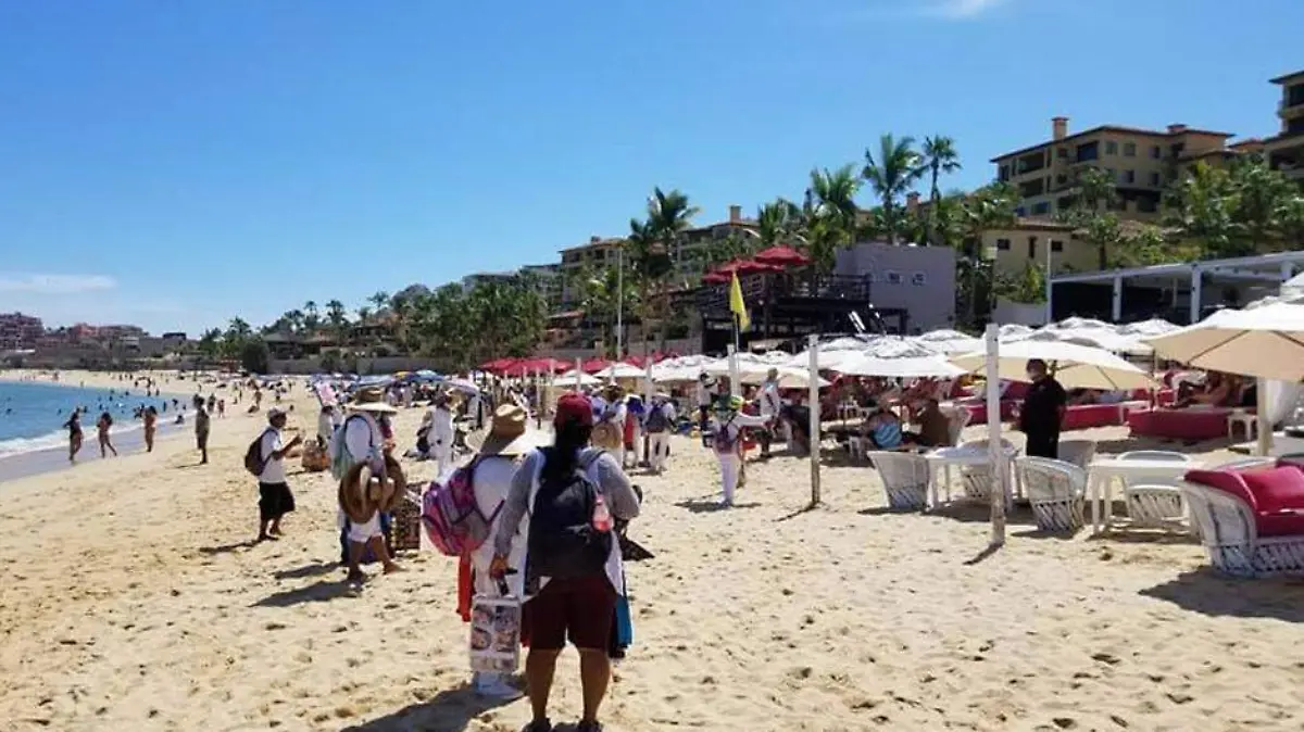 Turistas vendedores playa Los Cabos