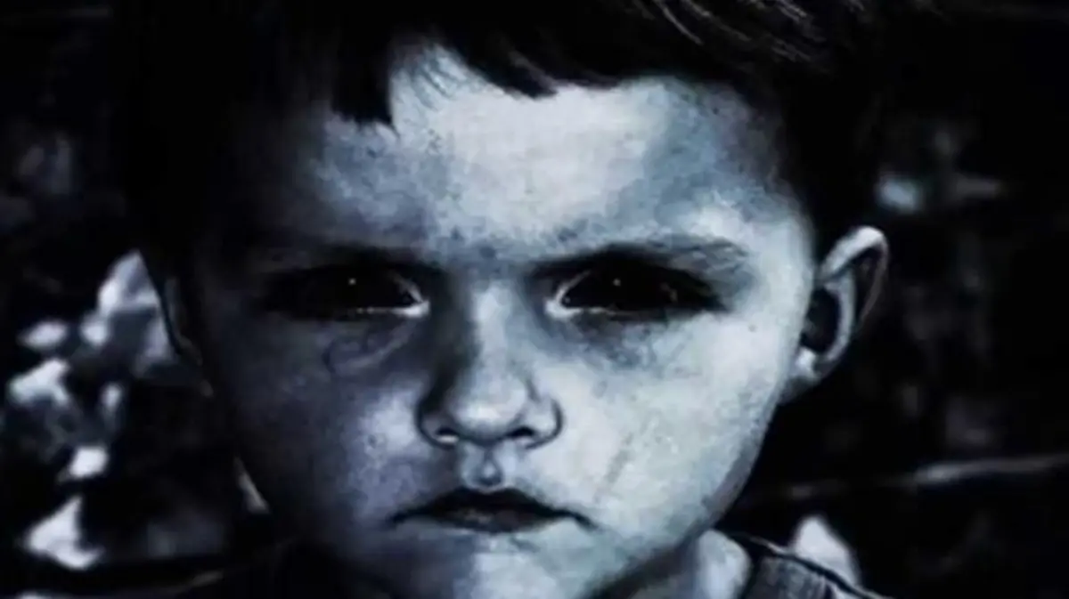 Niño que enseña los dientes