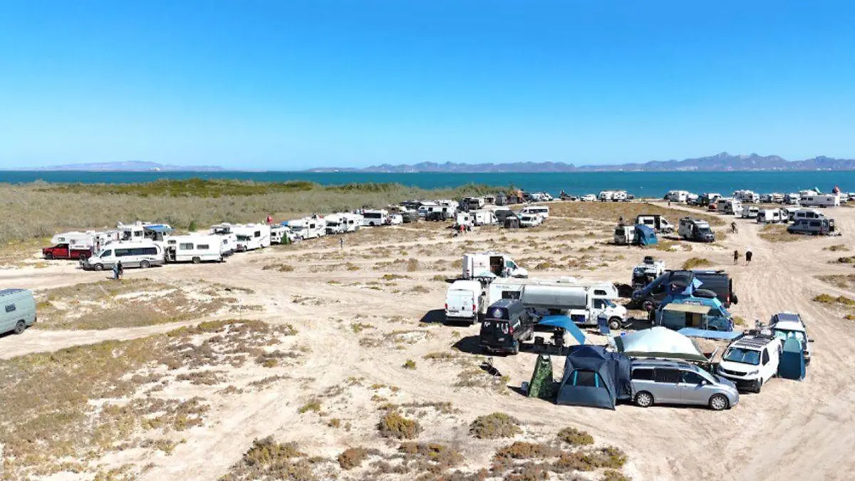 Piden a campistas estadounidenses recoger su basura en la playa El Comitán al retirarse