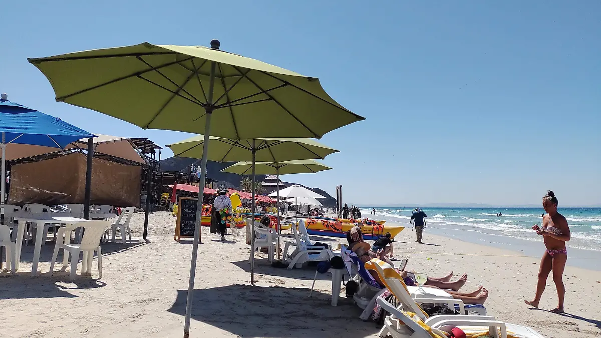 turistas en la playa de la paz