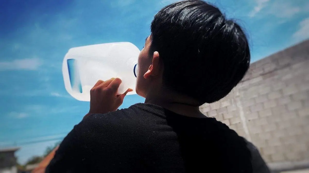 hombre-tomando-agua-bajo -sol