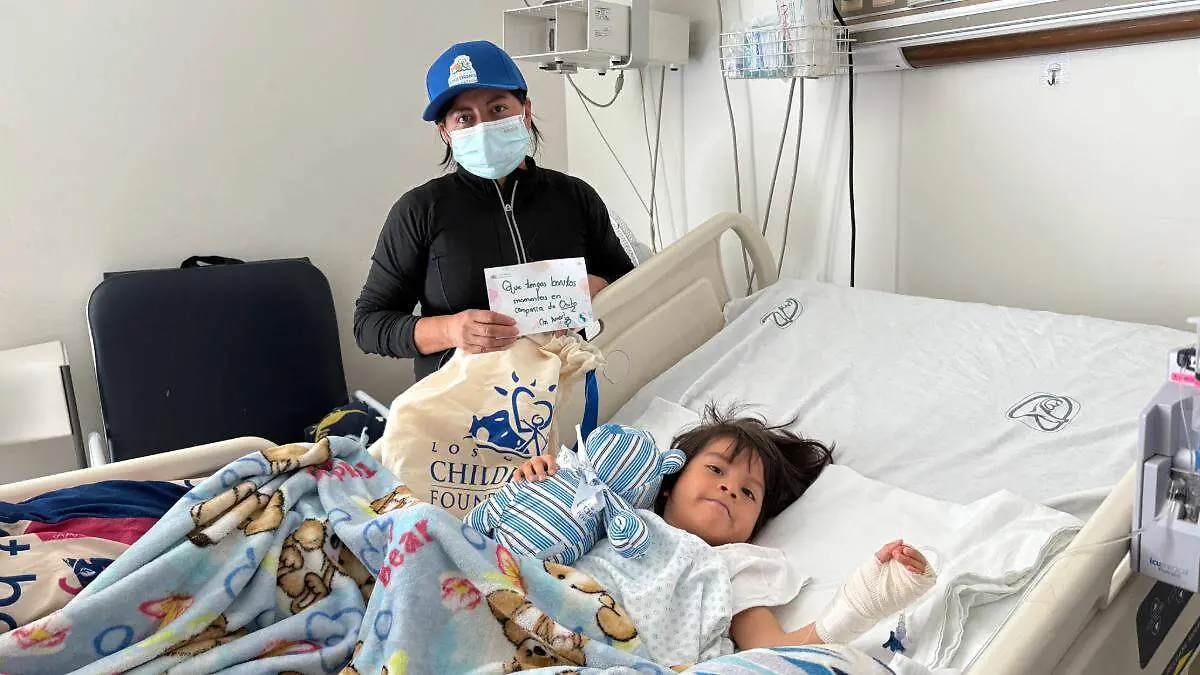 mujer-entregando-oso-pelucha-niña-con-cancer