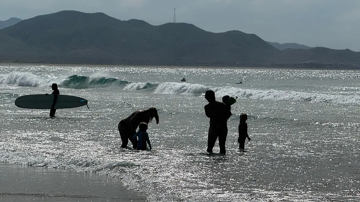 persona-tabla-surf-familia-nadando-orilla-mar