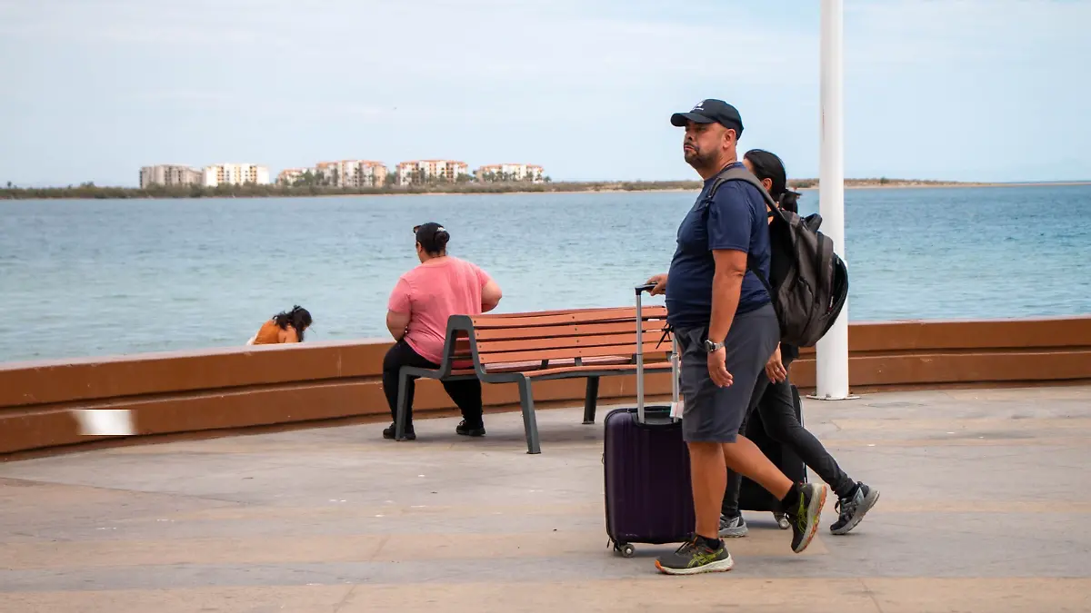 Turistas- caminan- en- el - malecon de la paz