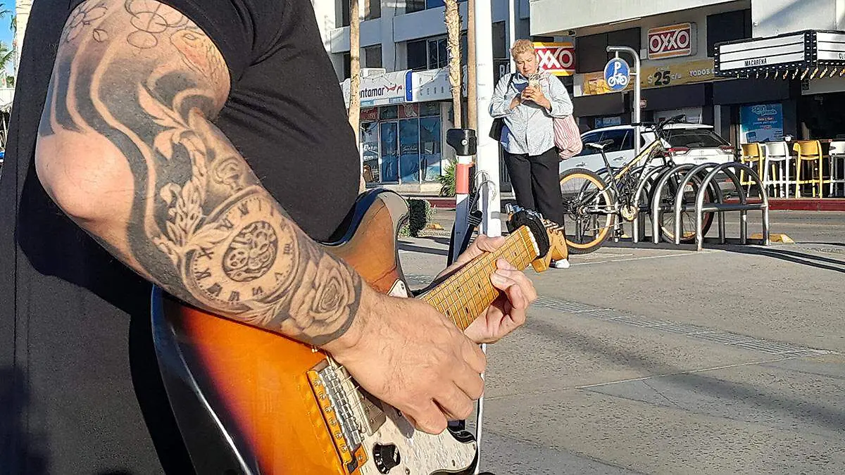 turista-grabando-musico-tito-trasviña-tocando-guitarra-malecon-la-paz