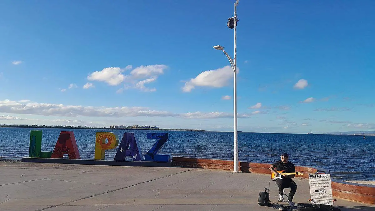 musico-tito-trasviña-tocando-guitarra-junto-letras-gigantes-malecon-la-paz