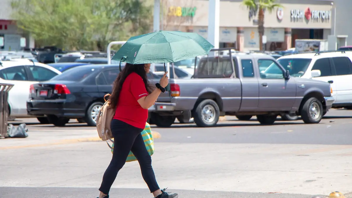 Se cubre el sol con sombrilla por calor