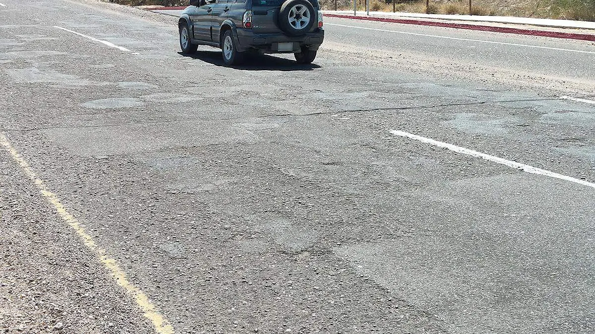 carro-pasando-por-calle-deteriorada