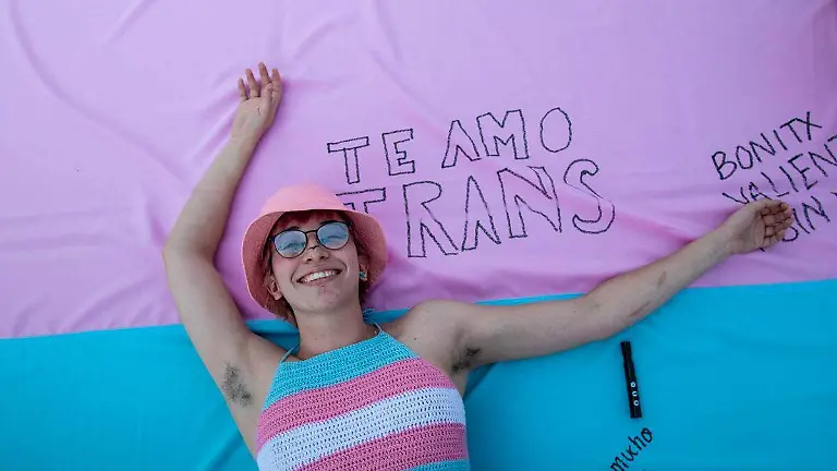 persona-sobre-una-bandera-de-la-comunidad-trans