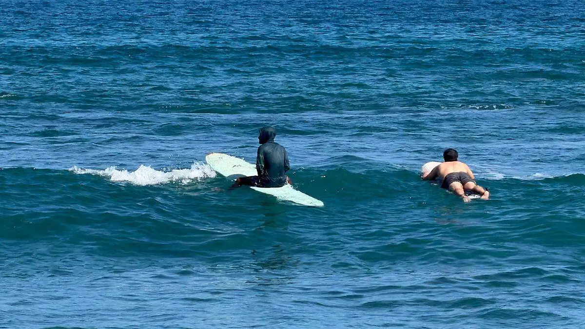 hombres-sobre-tabla-surf-mar