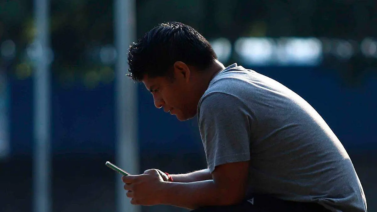 hombre-sentado-usando-celular