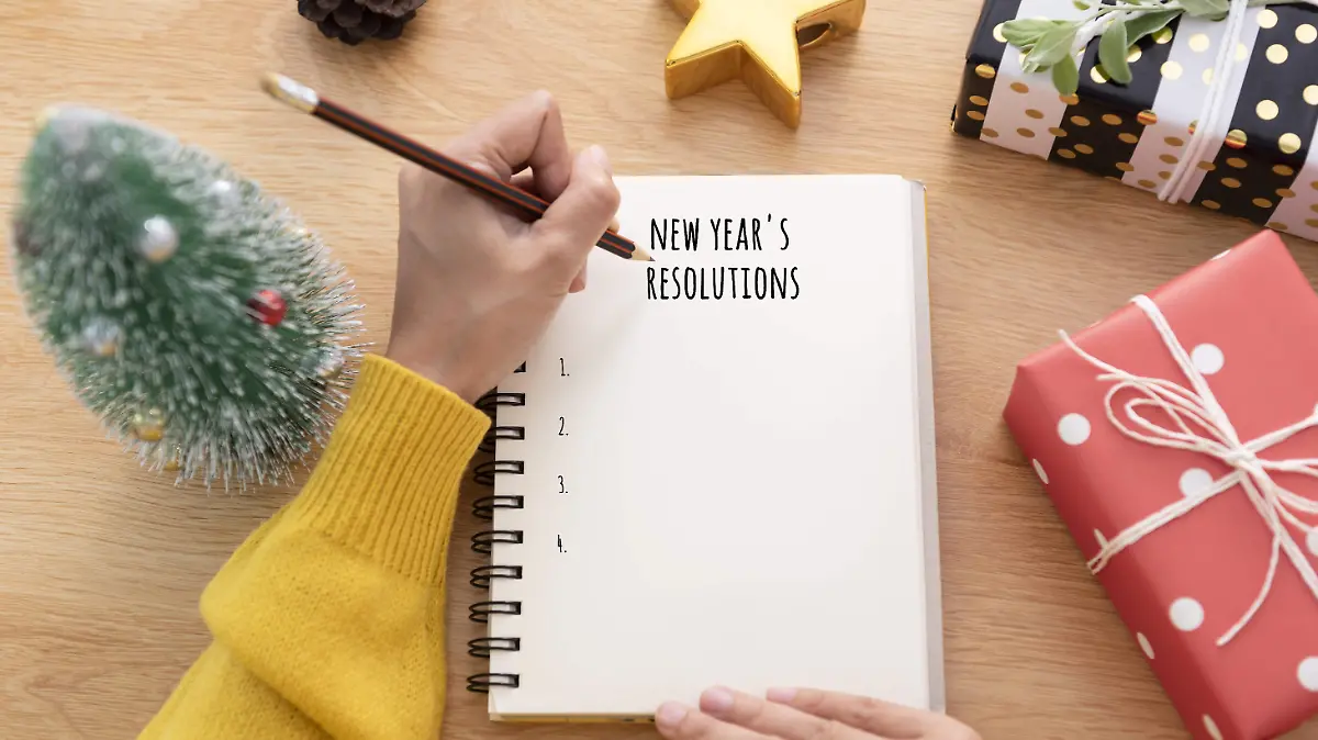 woman-hand-writing-new-years-resolution-on-note-paper-in-new-year-day