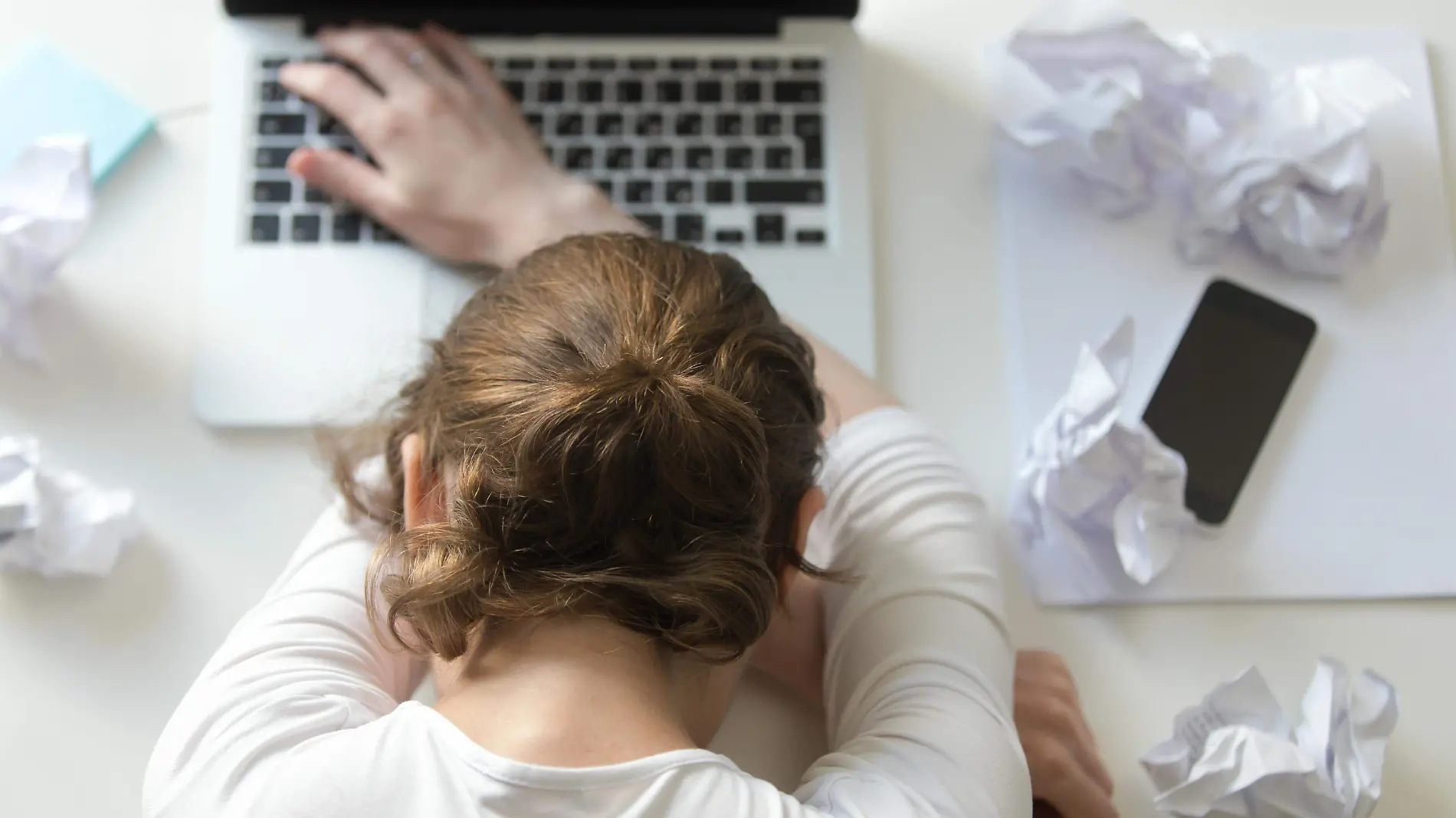 top-view-portrait-of-woman-lying-at-desk-near-the-laptop