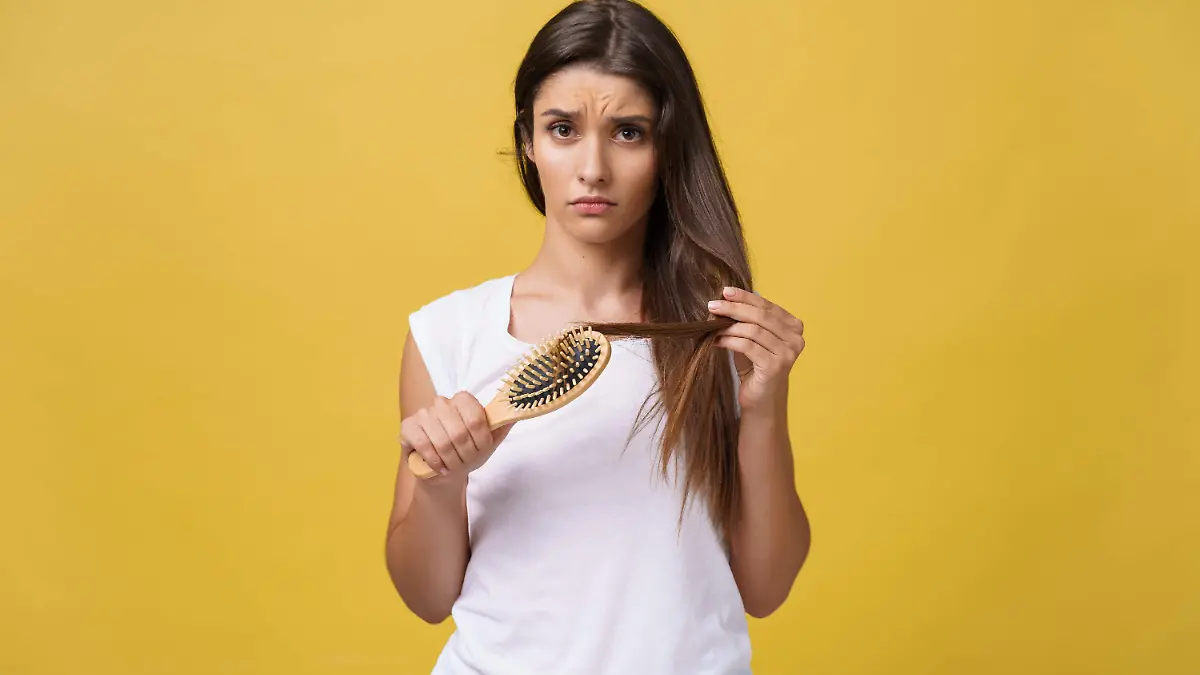 mano-mujer-sosteniendo-su-cabello-largo-mirar-puntas-divididas-danadas-problemas-cuidado-cabello