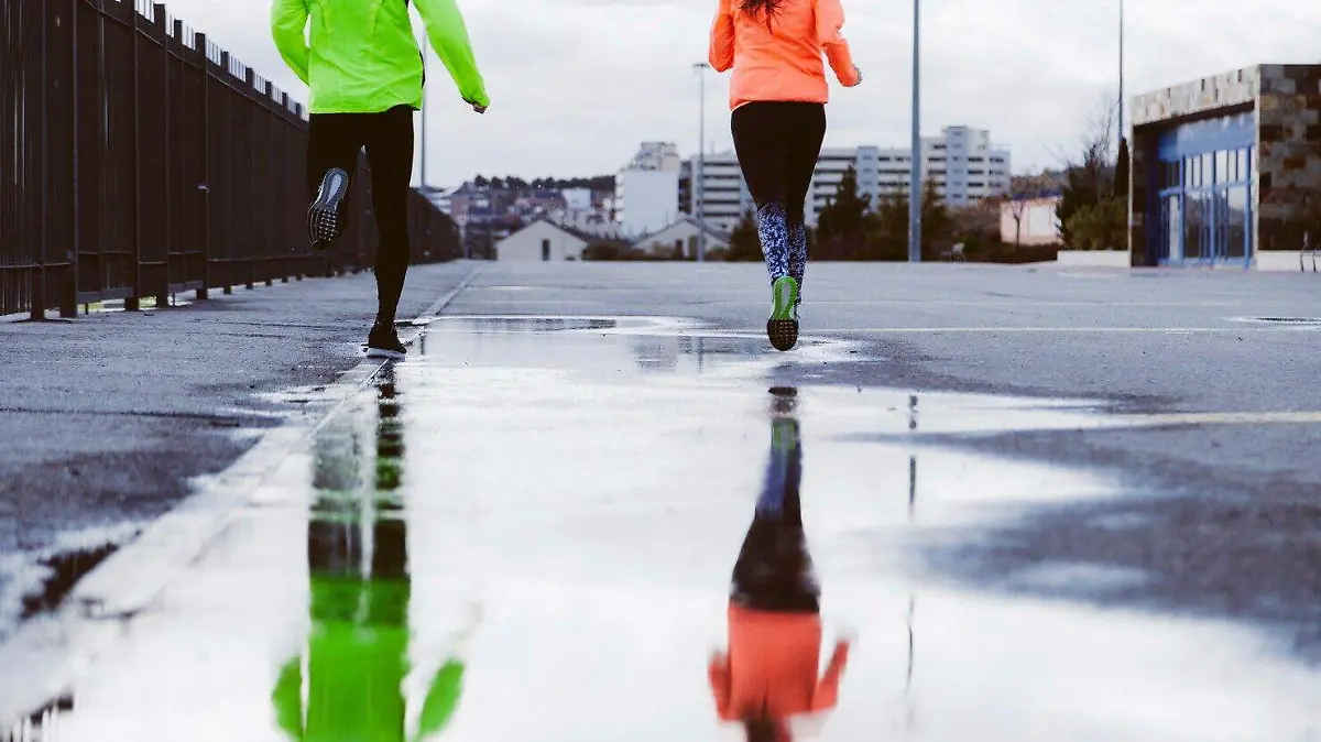 reflexion-dos-atletas-corriendo-calle-charco_23-2147839320