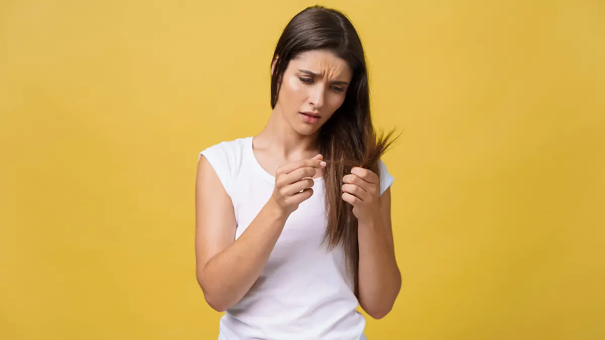 woman-hand-holding-her-long-hair-with-looking-damaged-splitting-ends-hair-care-problems