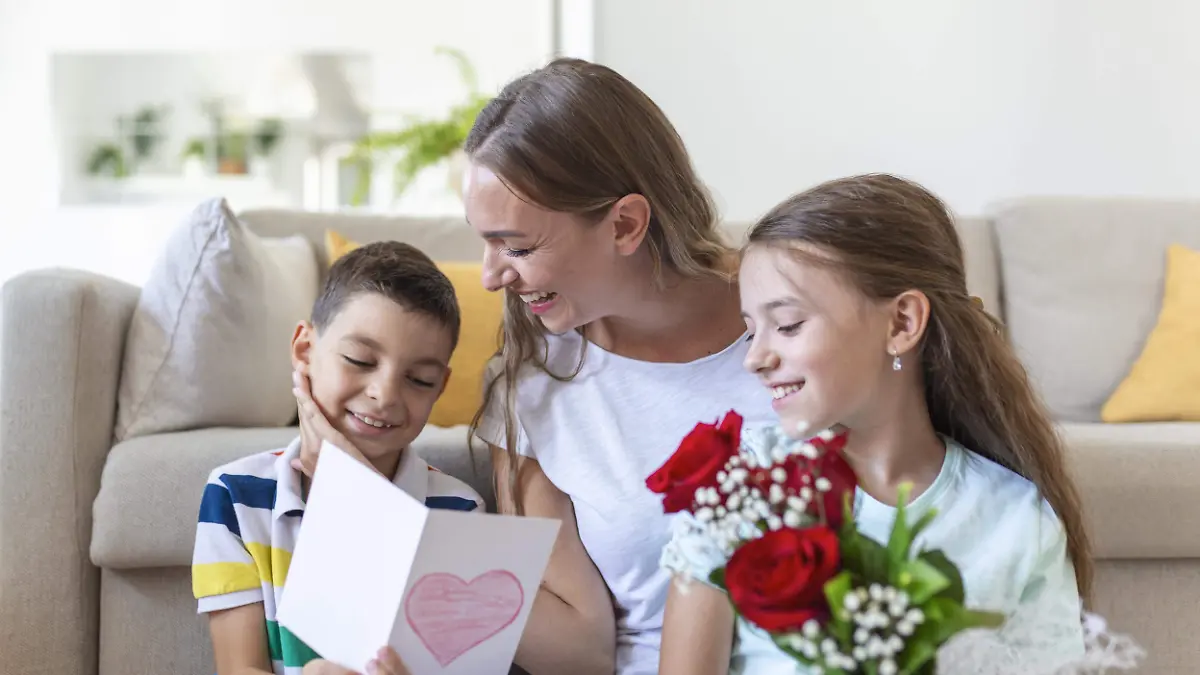 joven-madre-ramo-rosas-rie-abrazando-su-hijo-chica-transparente-tarjeta-felicita-mama-celebracion-navidena-cocina-casa