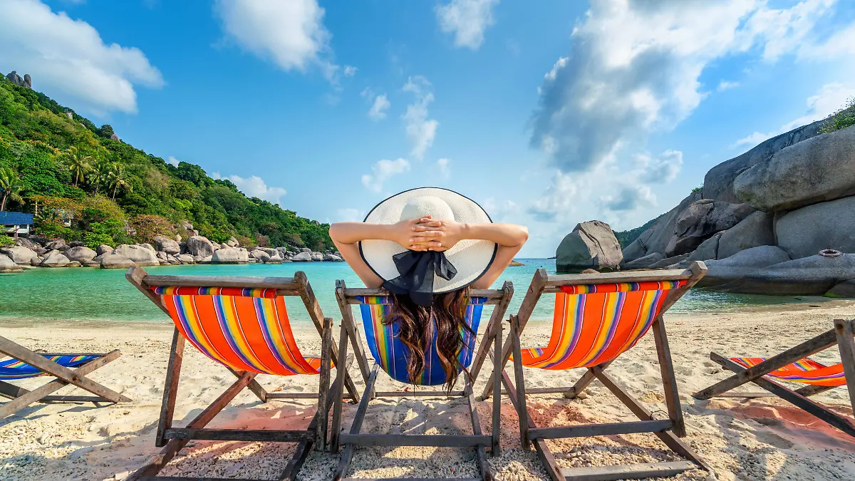 woman-with-hat-sitting-on-chairs-beach-in-beautiful-tropical-beach-woman-relaxing-on-tropical-beach-at-koh-nangyuan-island