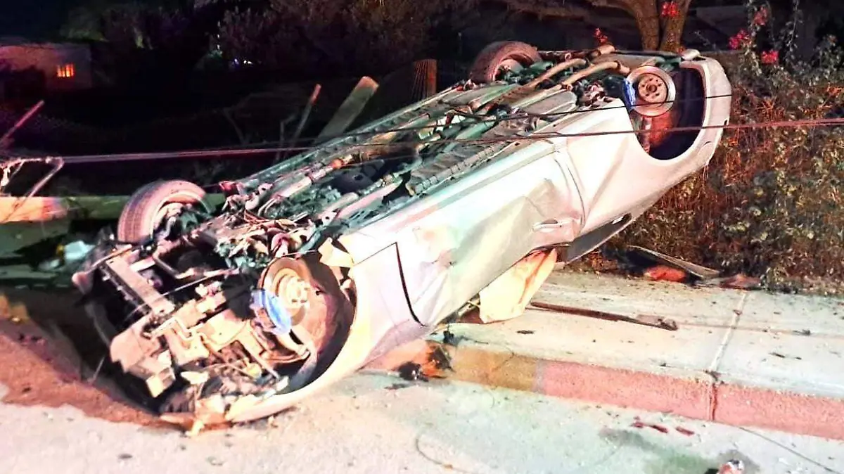 Vuelca auto tras chocar objetos fijos